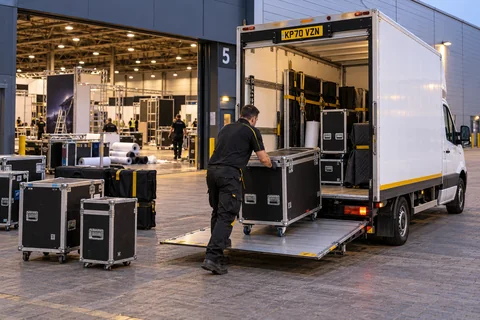 Courier moving a flight case onto a Luton tail lift during exhibition stand breakdown
